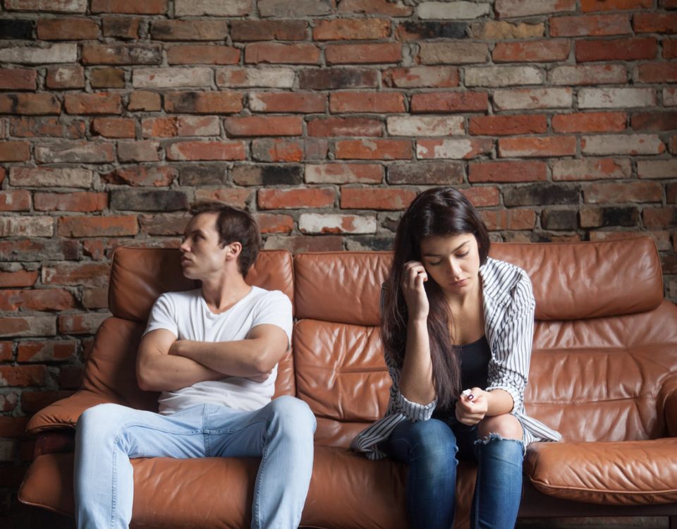 casal triste sentado no sofá