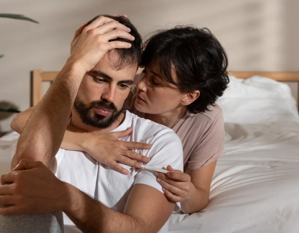 Imagem da uma mulher abtaçando seu marido preocupado para simbolizar a libido masculina