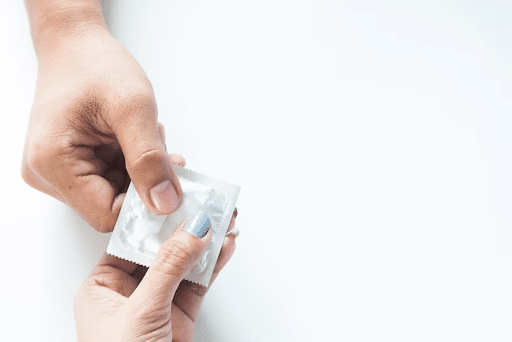 mãos segurando método contraceptivo para simbolizar as dst mais comuns em homens
