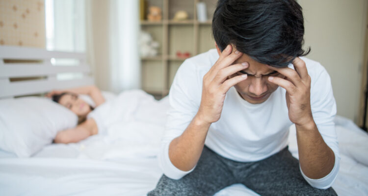 Imagem de uma mulher dormindo e um homem sentado na cama segurando a cabeça com as duas mãos para simbolizar o que é citrulina