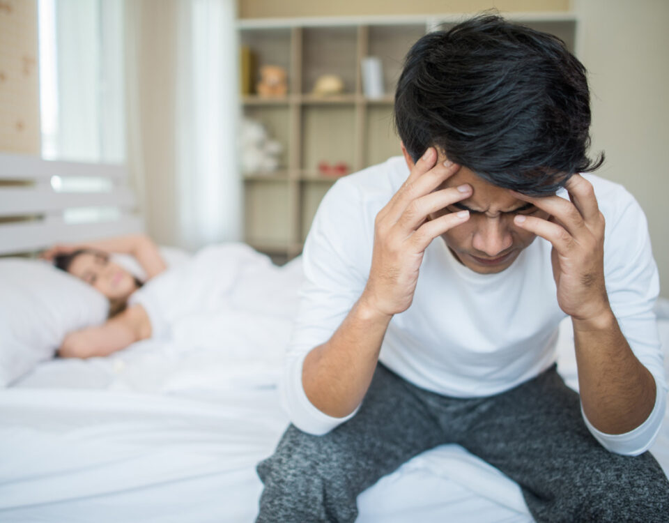 Imagem de uma mulher dormindo e um homem sentado na cama segurando a cabeça com as duas mãos para simbolizar o que é citrulina