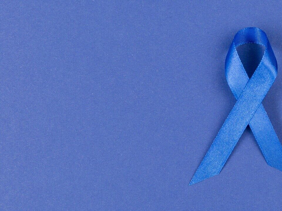 Imagem de uma capa azul com uma fitinha azul em homenagem e para simbolizar como prevenir o câncer de próstata