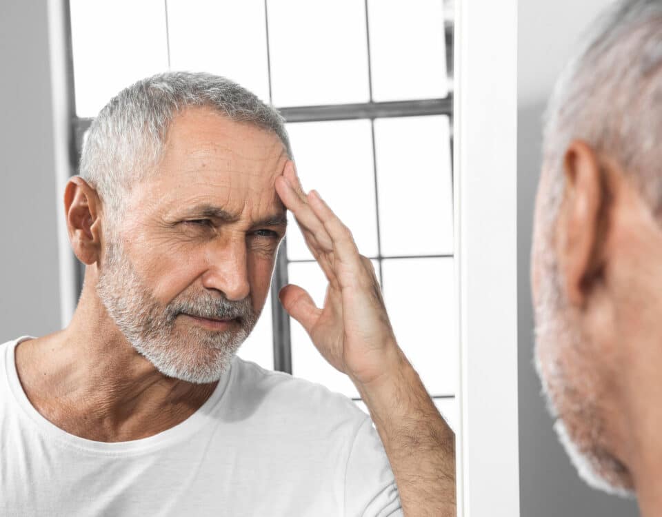 Imagem de um homem idoso se olhando no espelho para simbolizar a DAEM